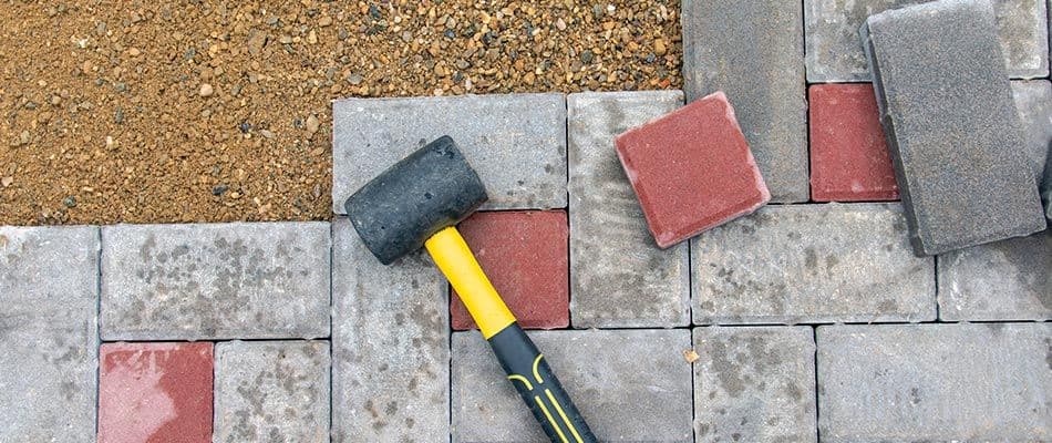 paver-patio-under-repair-with-hammer